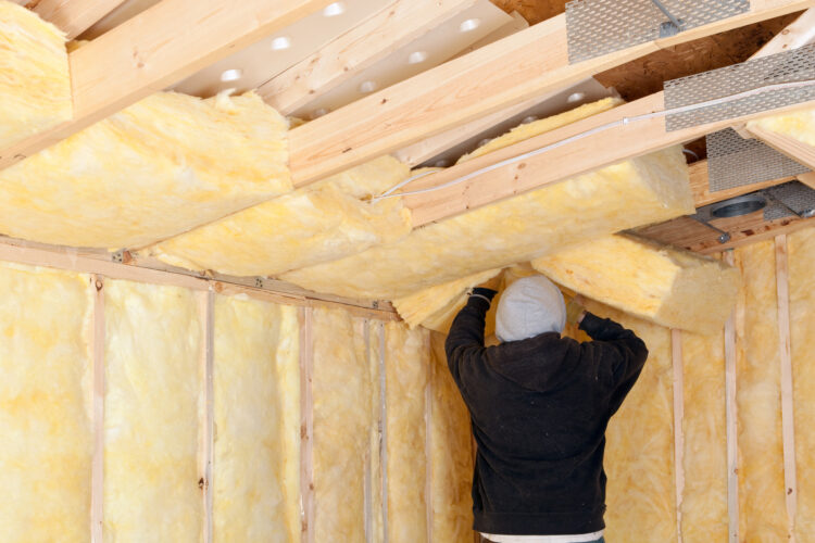 A professional installer applying insulation in an attic, ensuring proper coverage and air sealing